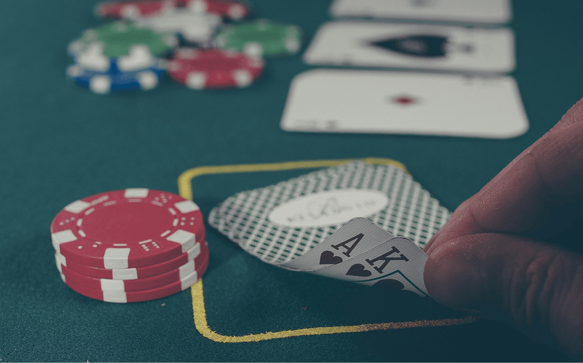 Ace and King in hand over a poker table
